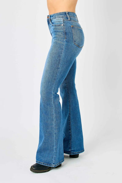 Full back view of the plus-size model wearing Judy Blue high-waisted flare jeans, showing the waistband and fit.