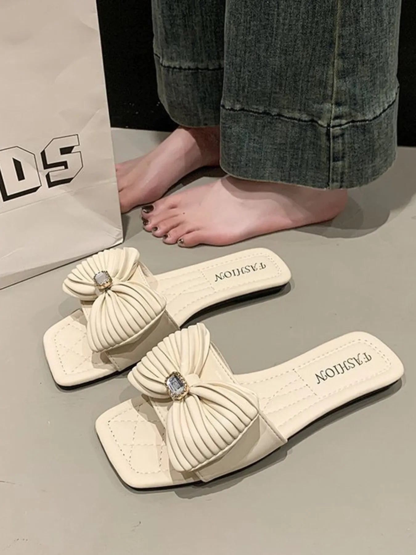 Angled view of Bow Knot Flat Sandals, showcasing the bow and flat, comfy sole design.
