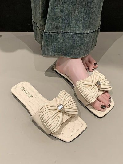 Side view of model wearing Bow Knot Flat Sandals, highlighting the bow detail and elegant fit.