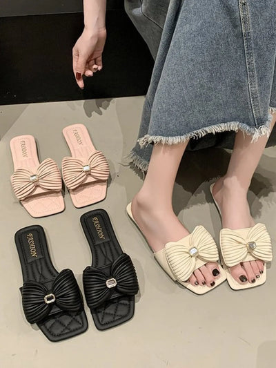 Black bow knot flat sandals for women, featuring a chic bow detail and comfortable flat sole, ideal for casual summer outfits