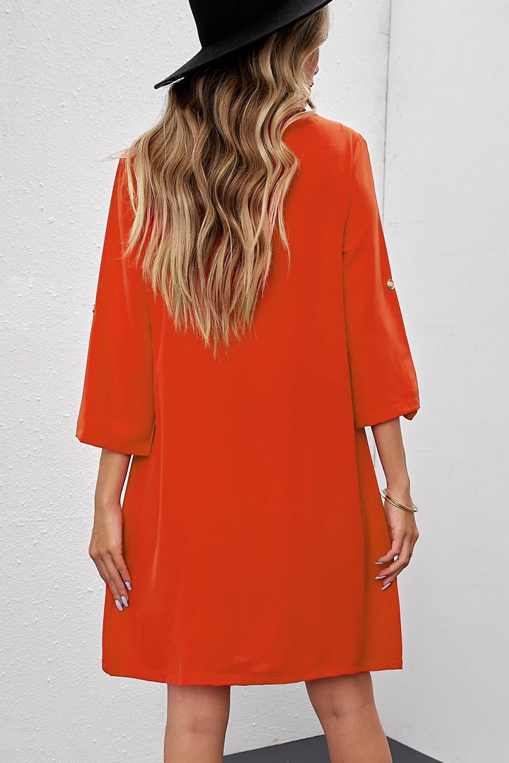 Angled back view of Buttoned V-Neck Dress on model, showing skirt movement and design.