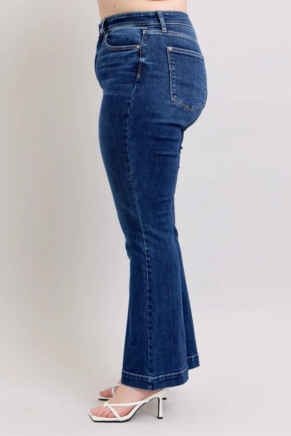 Model confidently posing in Judy Blue High-Rise Flare Jeans with pockets, showing the stylish and flattering fit for curvy women.
