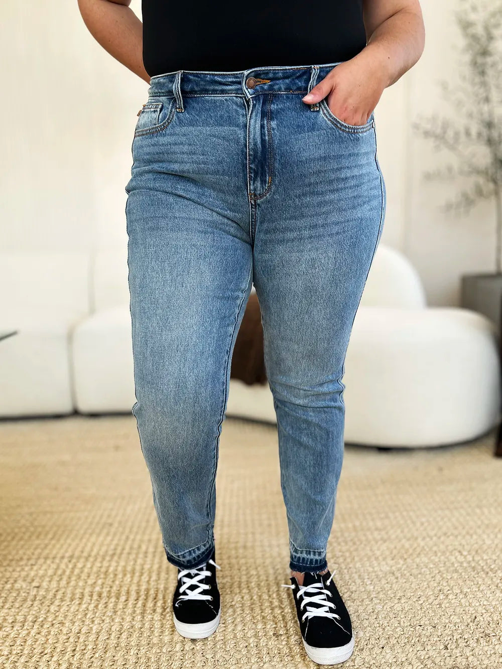 Side view of model showcasing Judy Blue Full Size Mid Rise Rigid Magic Release Hem Jeans.