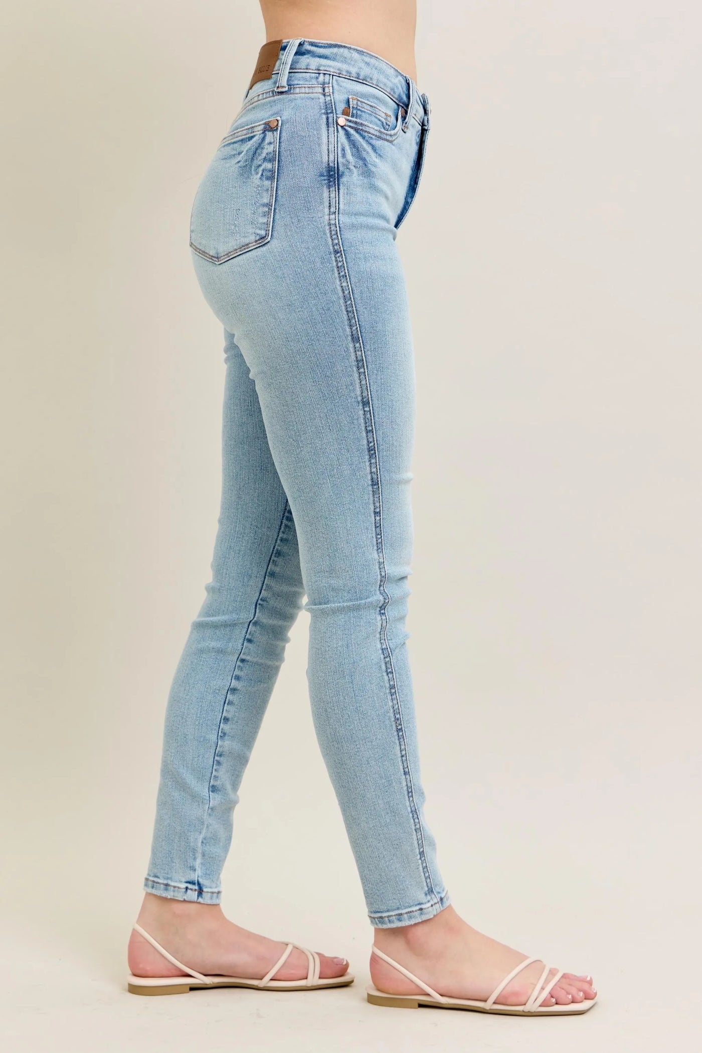 Side view showcasing the fit of Judy Blue Full Size Mid Rise Tummy Control Vintage Wash Skinny Jeans Plus Size.