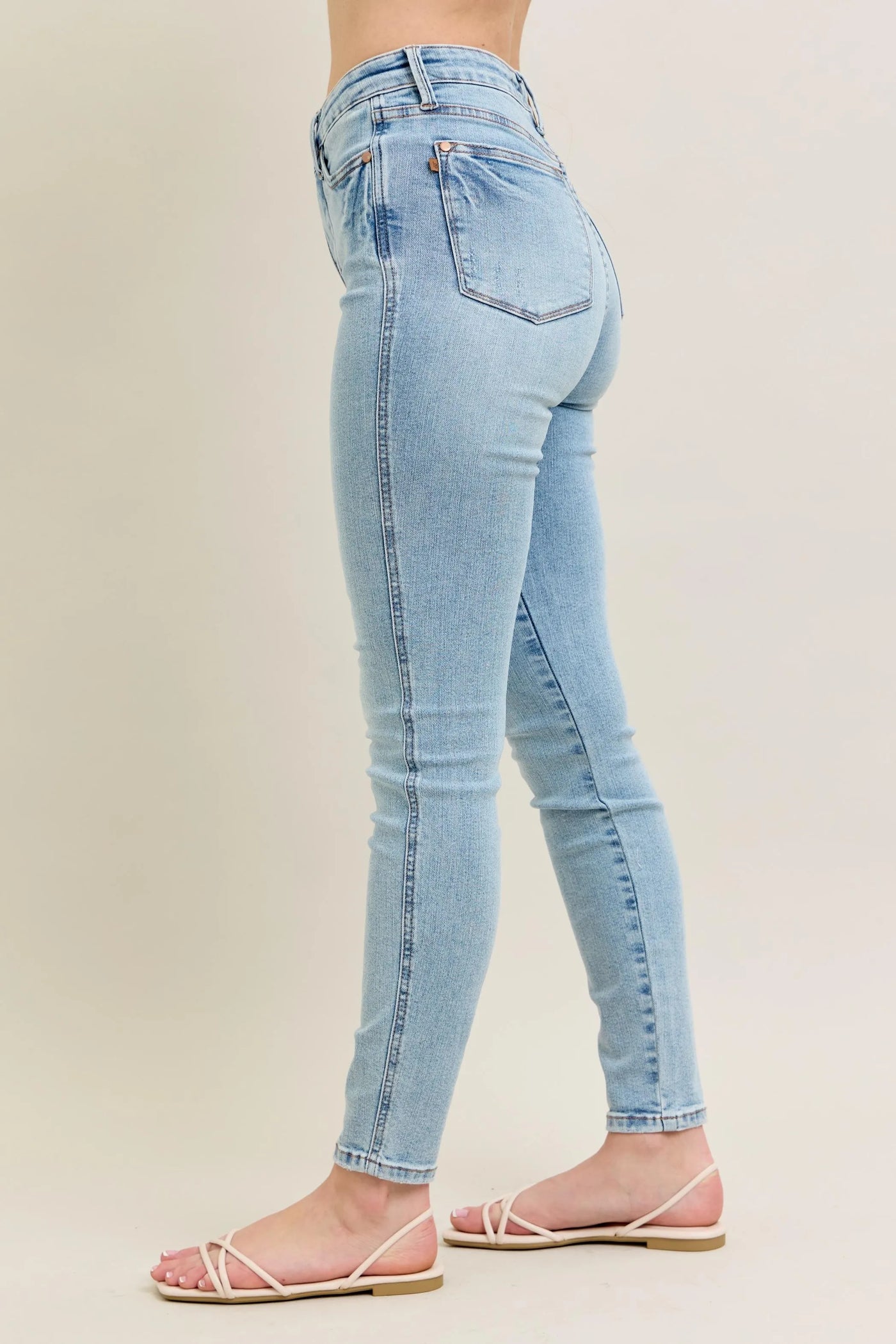 Angled front view of Judy Blue Full Size Mid Rise Tummy Control Vintage Wash Skinny Jeans Plus Size, showcasing the silhouette.