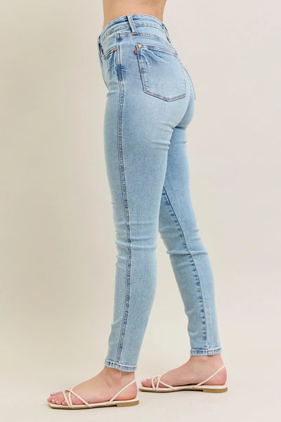 Angled front view of Judy Blue Full Size Mid Rise Tummy Control Vintage Wash Skinny Jeans Plus Size, showcasing the silhouette.