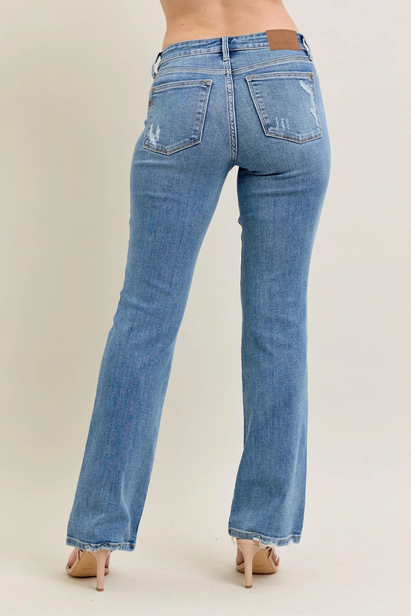 Close-up side view emphasizing the bootcut flare of Judy Blue Full Size Mid Rise Wash Destroy Hem Bootcut Jeans Plus Size.