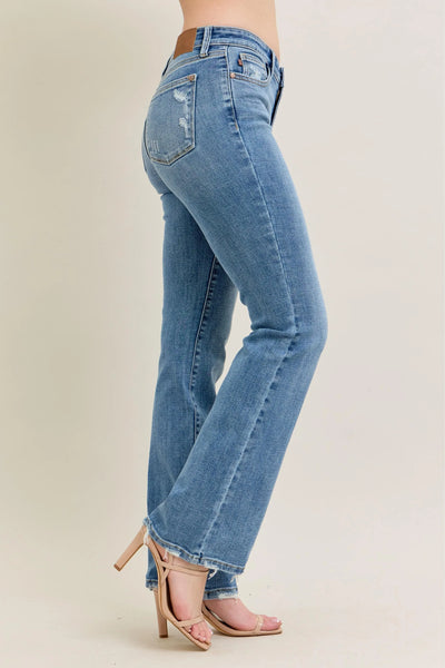 Angled back view of Judy Blue Full Size Mid Rise Wash Destroy Hem Bootcut Jeans Plus Size, highlighting the fit.