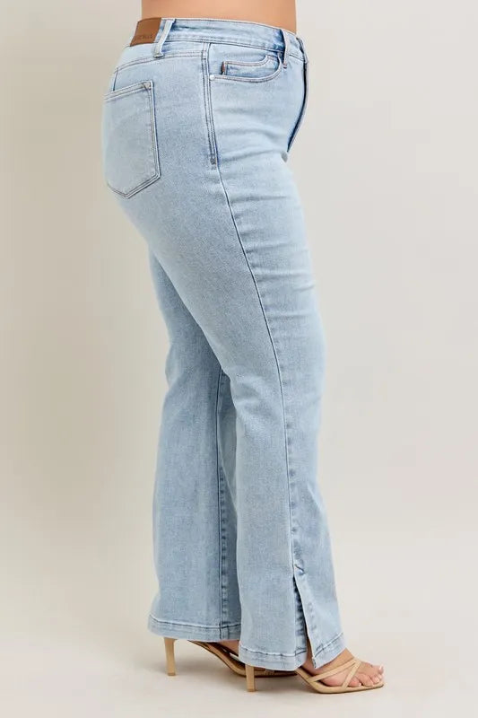 Side view of model showcasing Judy Blue Full Size Tummy Control Vintage Wash Side Slit Slim Boot Jeans Plus Size.