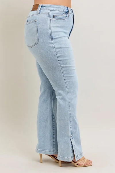 Side view of model showcasing Judy Blue Full Size Tummy Control Vintage Wash Side Slit Slim Boot Jeans Plus Size.