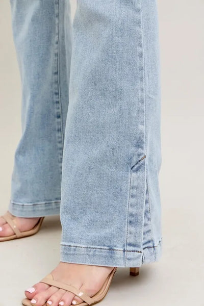 Angled front view of Judy Blue Full Size Tummy Control Vintage Wash Side Slit Slim Boot Jeans Plus Size, showcasing the silhouette.