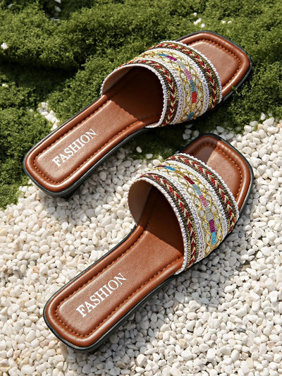 Close-up detail of straps on open toe flats sandals in white