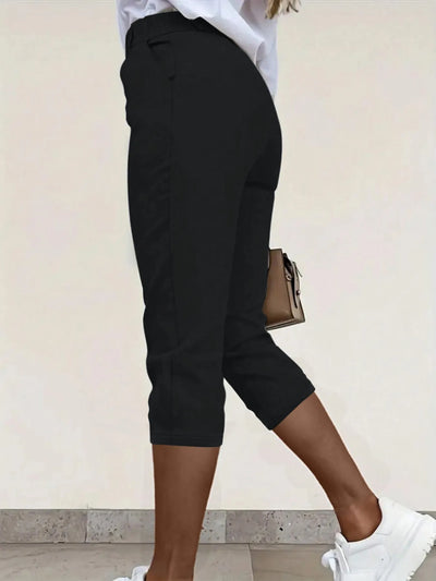 Back view highlighting the design of pleated detail pants in black