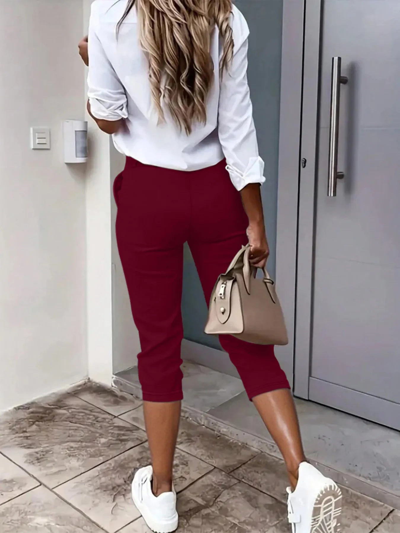Side view showcasing the fit of pleated detail pants in burgundy
