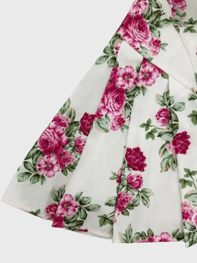 Detail view of waistband and pleat on deep red floral mini dress