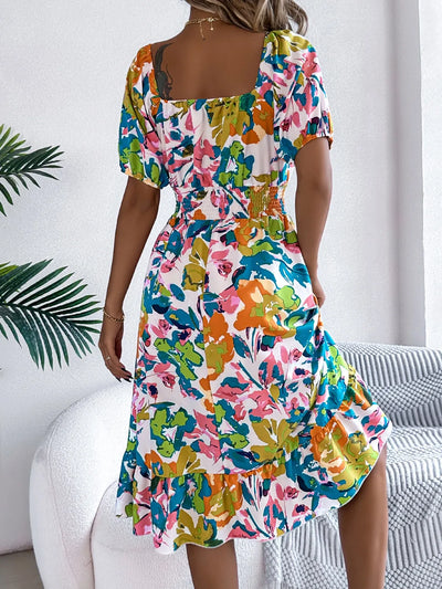Back view of model wearing Ruffled Hem Smocked Floral Short Sleeve Midi Dress, showcasing the ruffled hem and smocked bodice.
