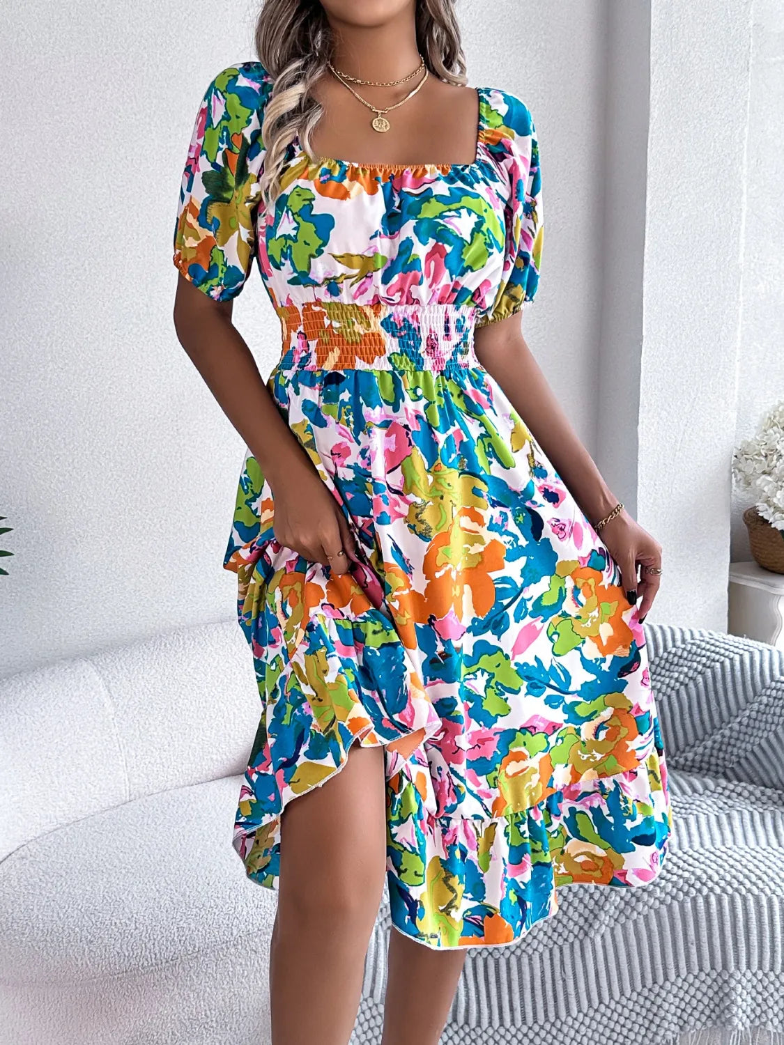 Side view of model wearing Ruffled Hem Smocked Floral Short Sleeve Midi Dress, highlighting the relaxed and flowy fit.