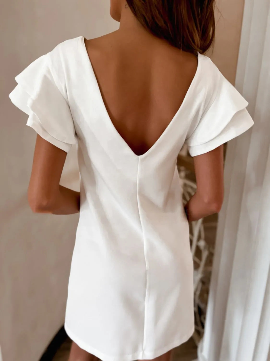 Back view highlighting the design of Ruffled Layered Short Sleeve Mini Dress in White