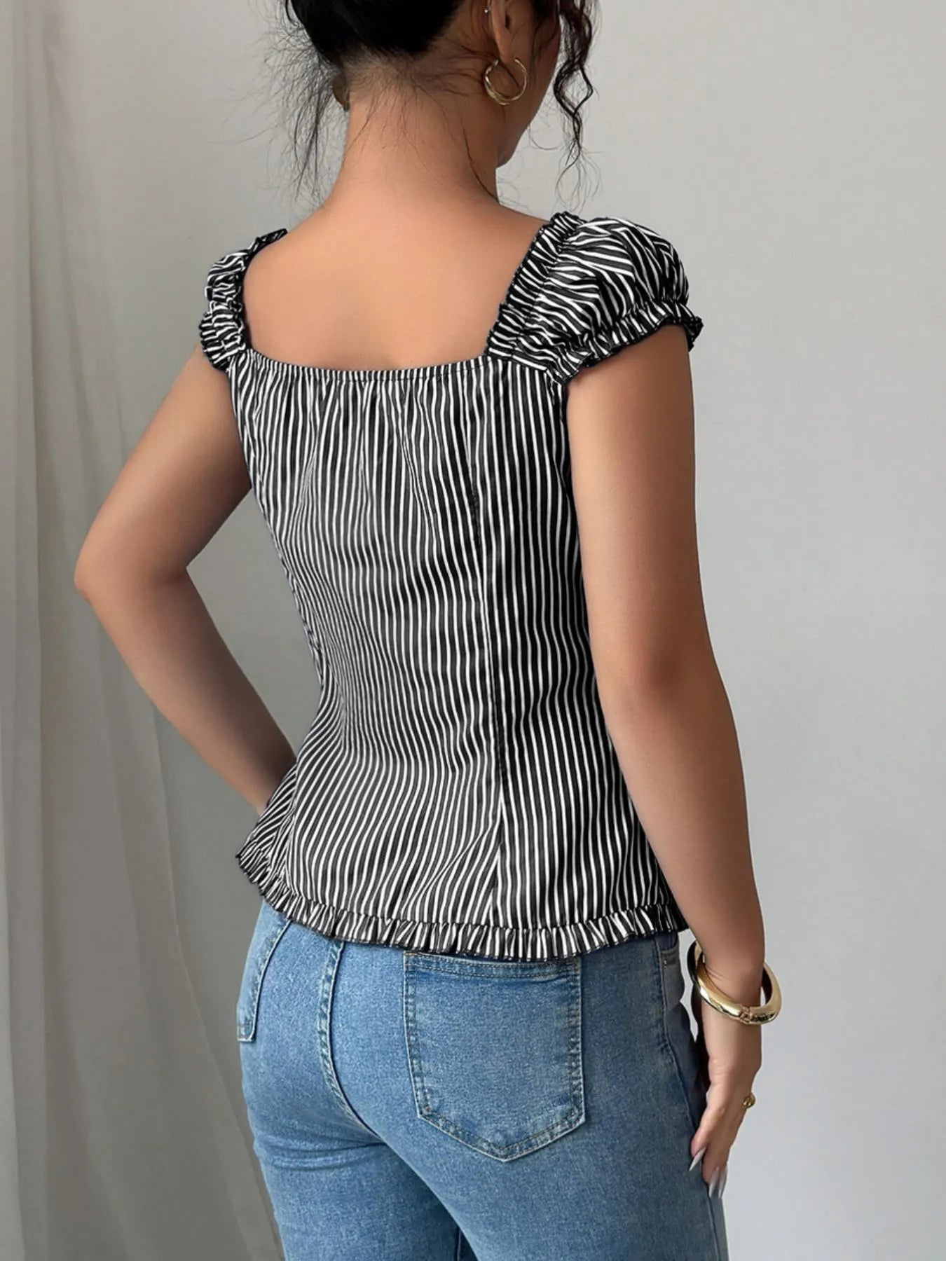 Side view showcasing the fit of Striped Cap Sleeve Shirt in Black