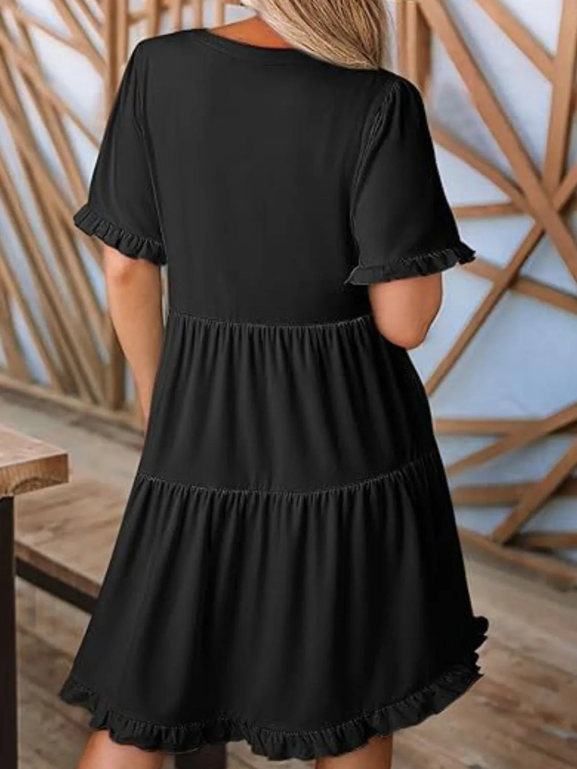 Back view highlighting the design of Tiered Notched Short Sleeve Mini Dress in Black