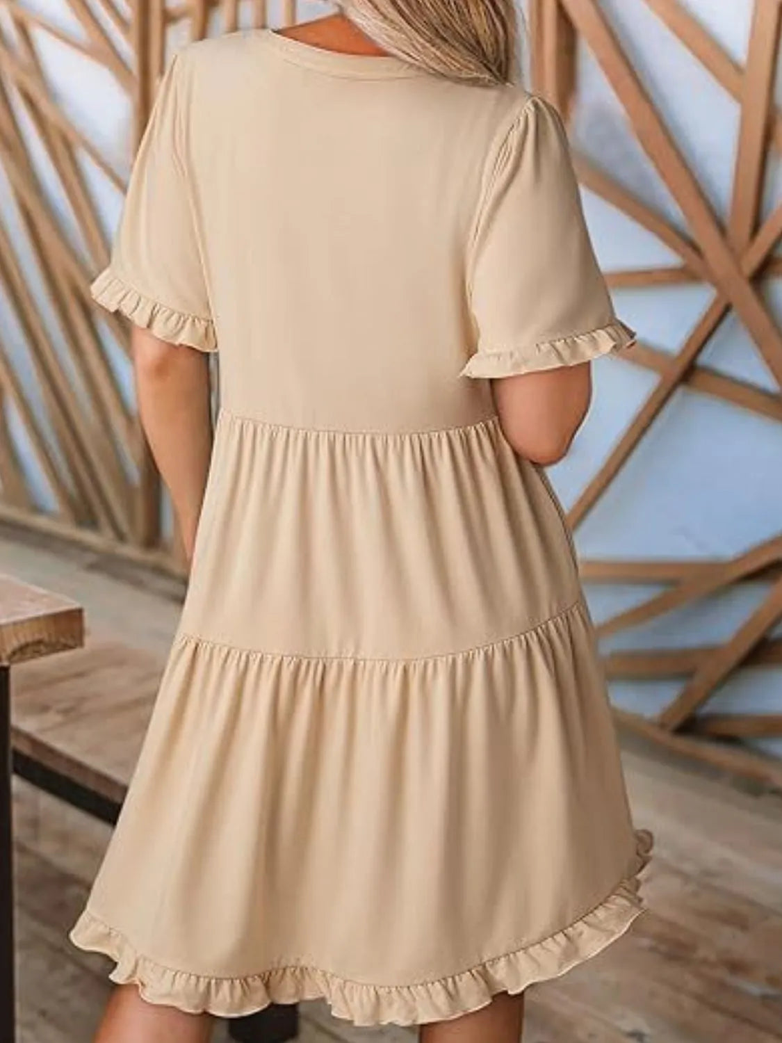 Back view highlighting the design of Tiered Notched Short Sleeve Mini Dress in Tan
