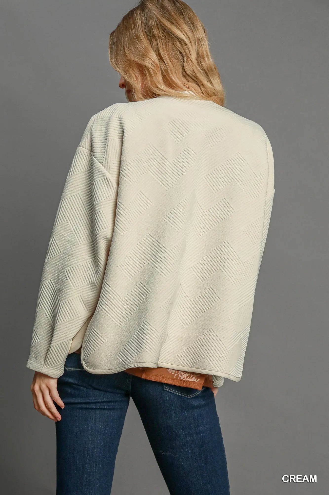 Close-up of the hemline on Umgee Textured Jacquard Jacket, highlighting the elegant finish and tailored fit.