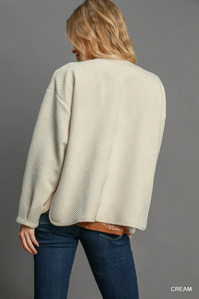 Close-up of the hemline on Umgee Textured Jacquard Jacket, highlighting the elegant finish and tailored fit.